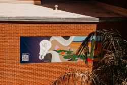 A banner hung outside the Harvill building. It depicts the LED project and has a QR code in the corner.