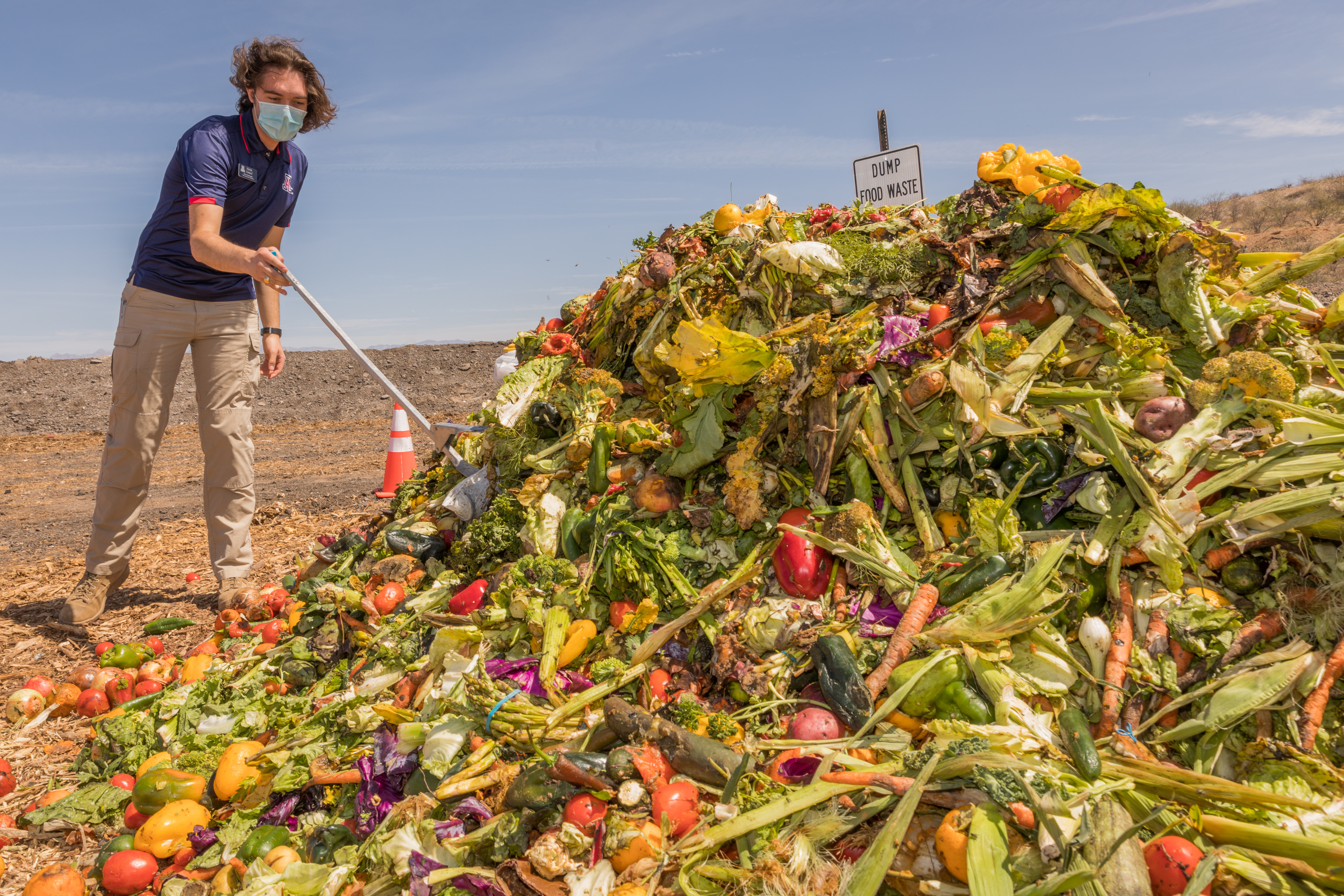 A student removes a plastic bag from a pile of food waste