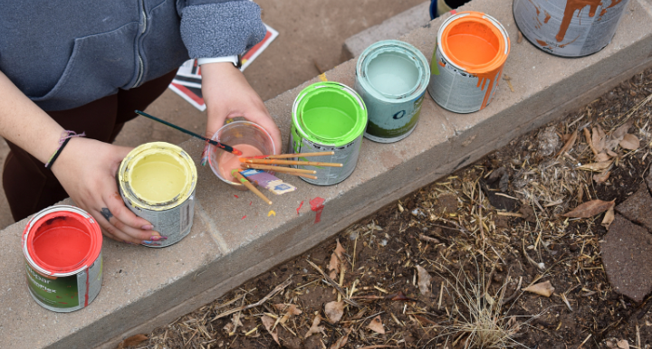 Small buckets of colorful paint in a row