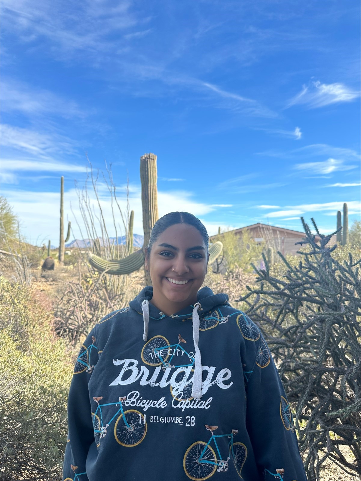 A person smiling in front of a desert.