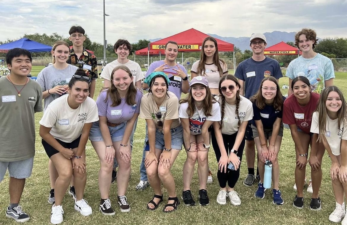 A large group of students stand together smiling at the camera.