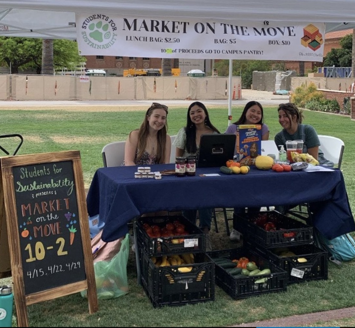 Students at a tabling event selling produce.