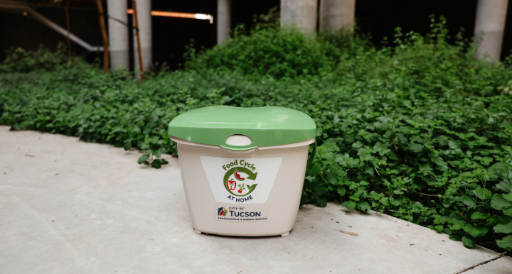 FoodCycle at Home pail, used to collect food waste, surrounded by greenery.