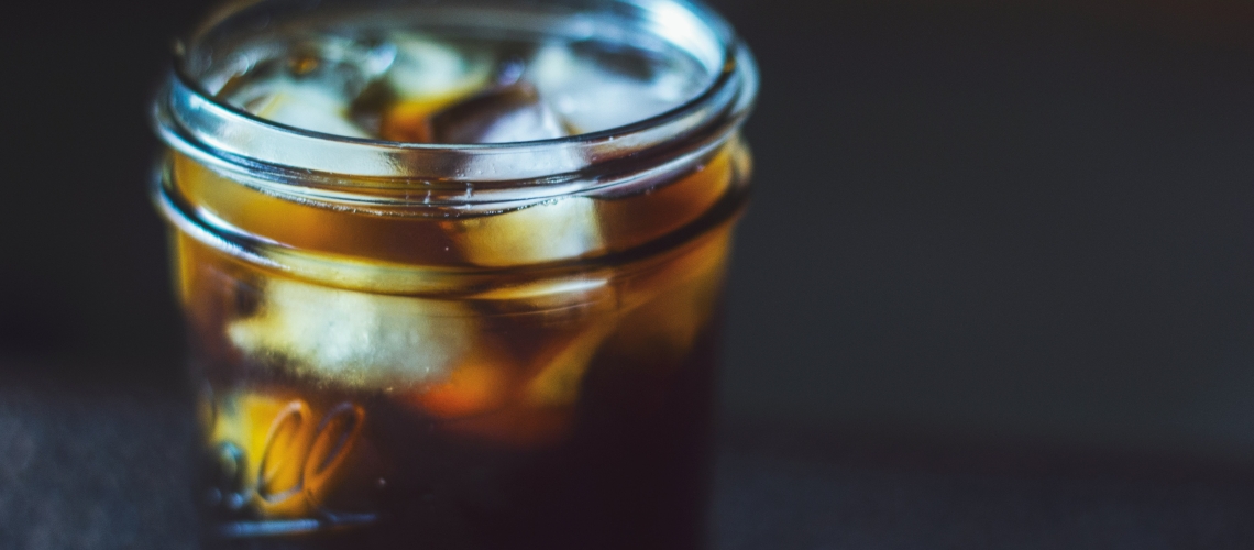 mason jar with ice and soda or tea inside