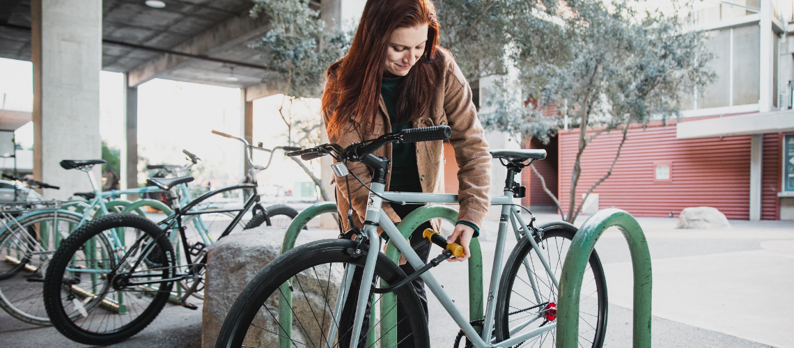 A student locks her bike to a bike rack