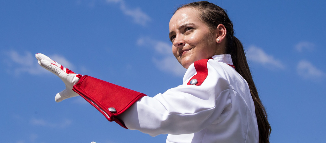 Grace Adams in band uniform conducting a band