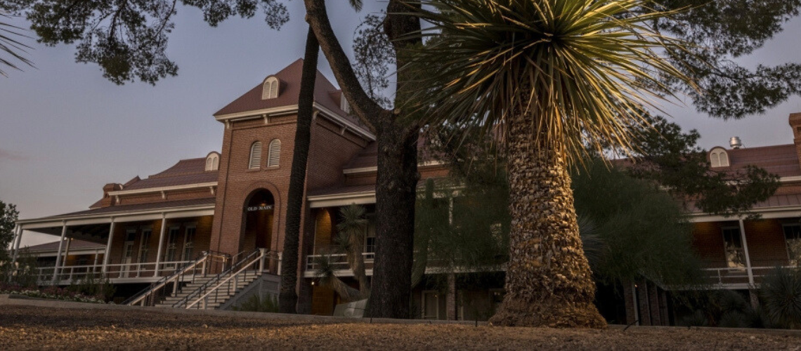 Shot from a low angle, looking up at Old Main at twilight with a darkening night sky above