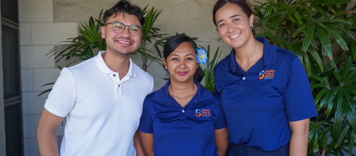 Javier Aguiniga with the WEST EJ Center poses with two employees of the Hawai'i Public Health Institute at a community outreach event. 