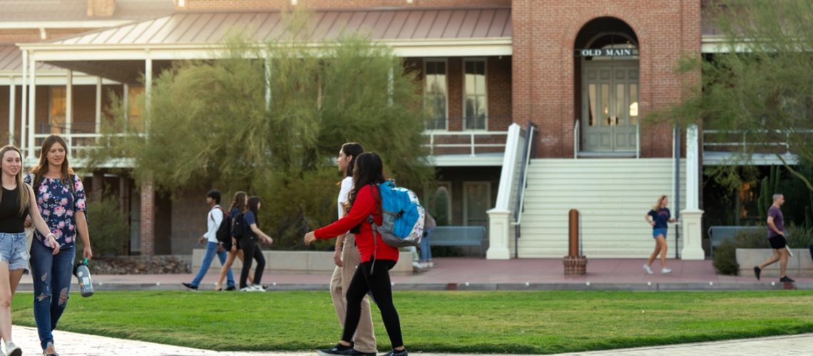students walk on paths in front of Old Main