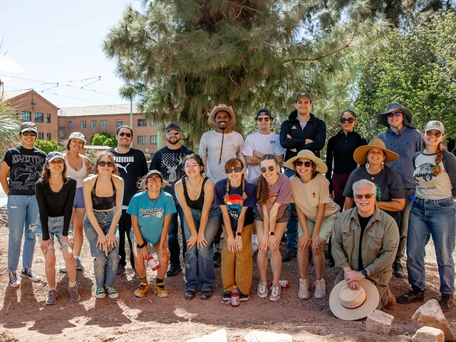 A group of people standing next to each other and smiling for a group photo.