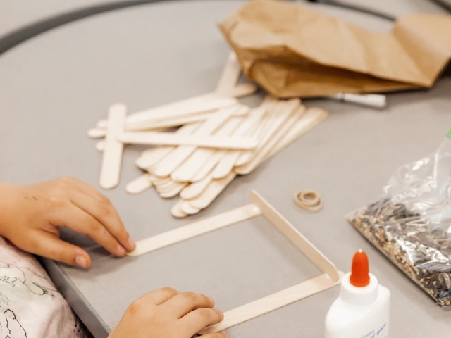 A person glueing wooden popsicle sticks together in the shape of a square.