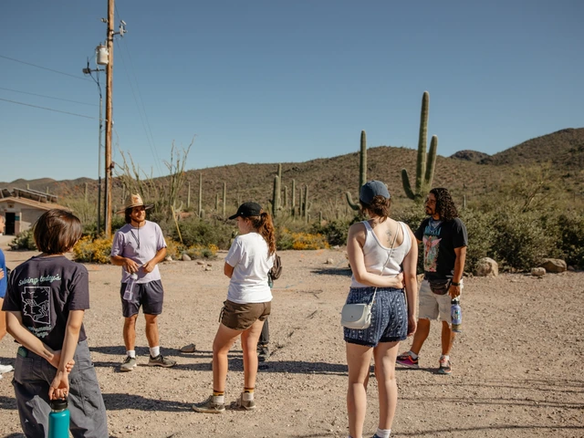 A group of people standing outside in a desert area.