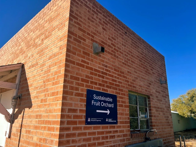 A red brick building with a blue sign on the wall.