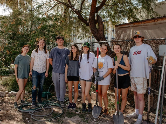 A group of people standing next to each other smiling for a photo.