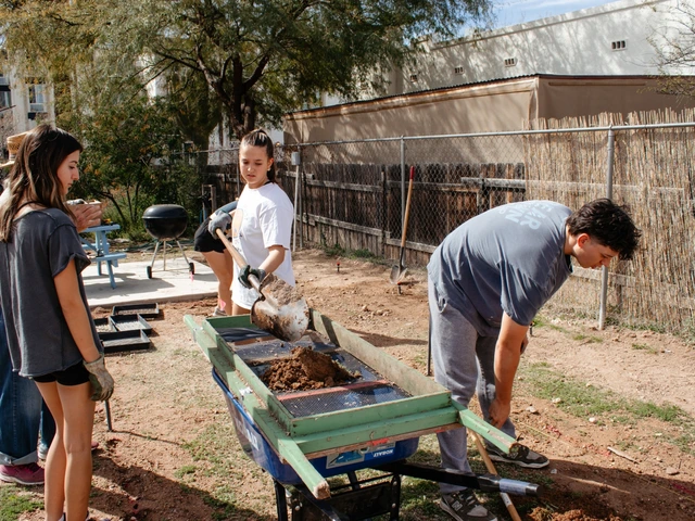 A group of people holding shovels and digging.