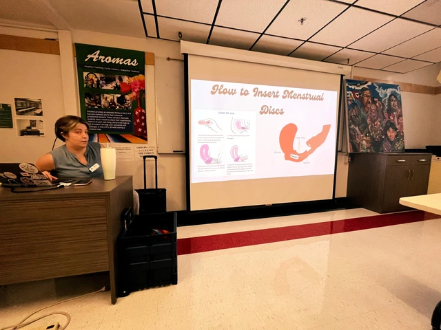 A person sitting next to a projector screen.