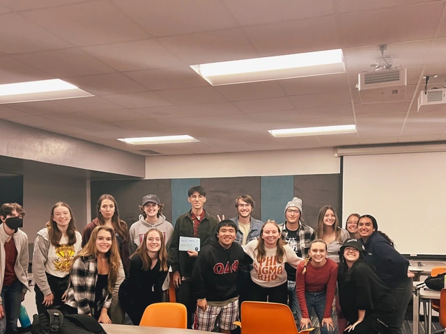A group of students posing for a photo in a classroom. 