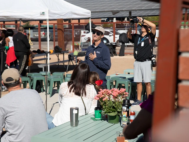 A person standing in front of a crowd smiles while holding a microphone.