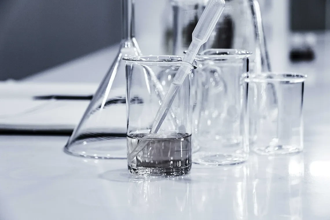 Images of glass chemistry beakers in a lab.