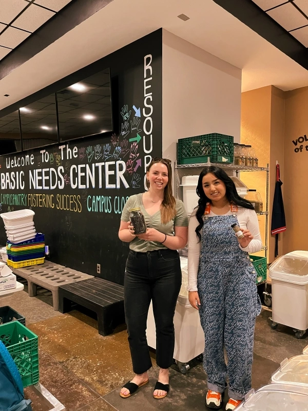 2 people holding jars. 