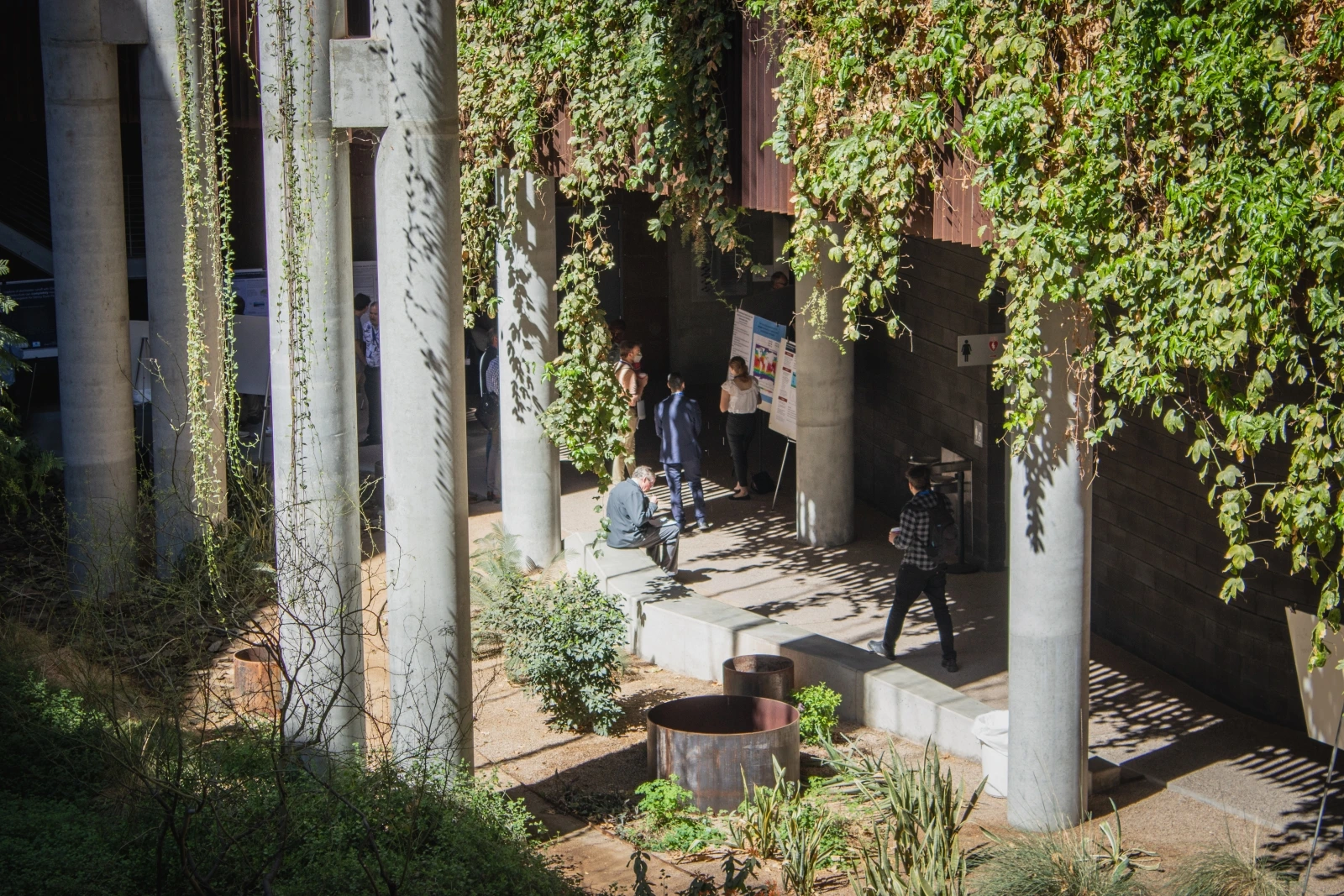 A group of people attending poster presentations. 