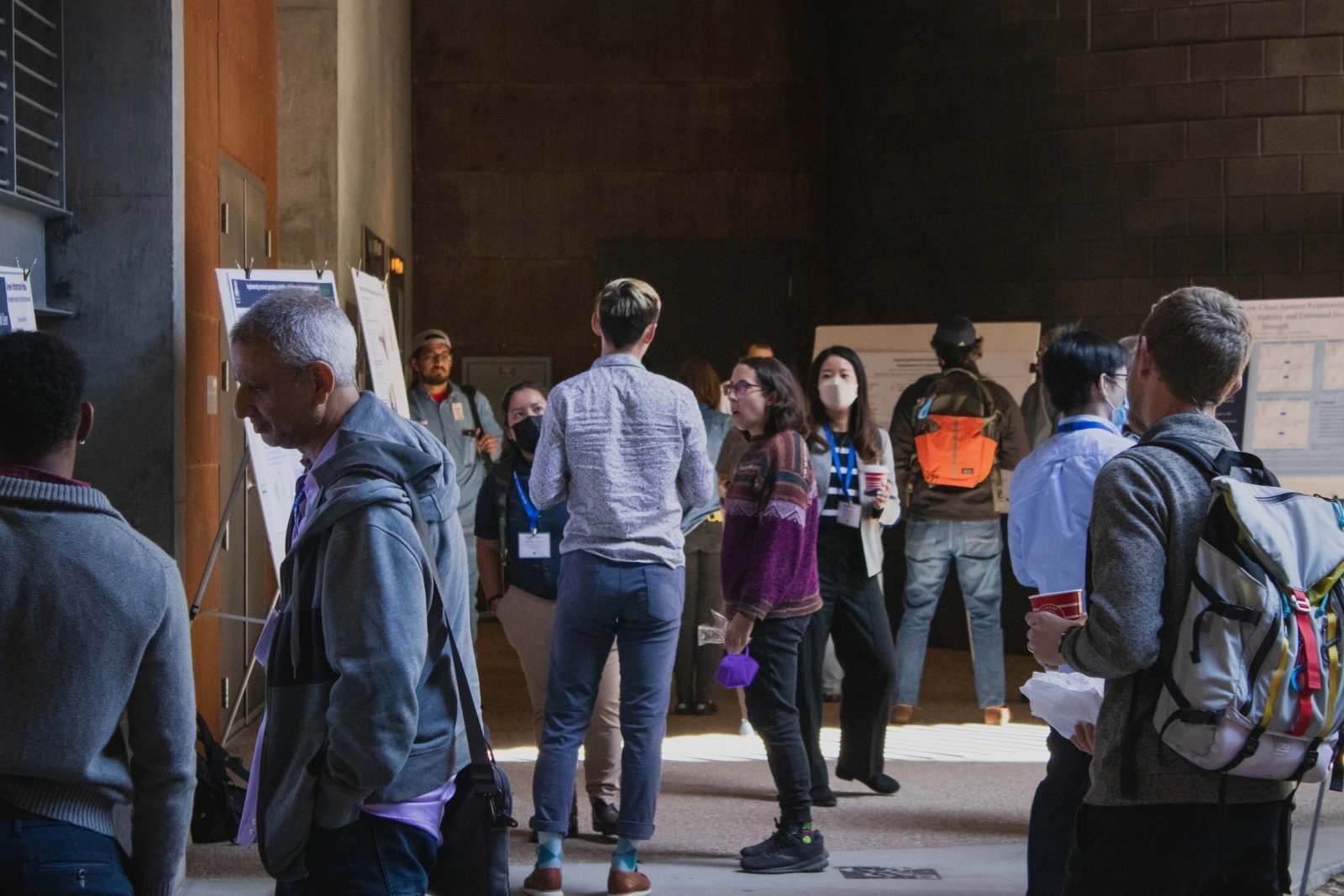 A group of people attending poster presentations. 