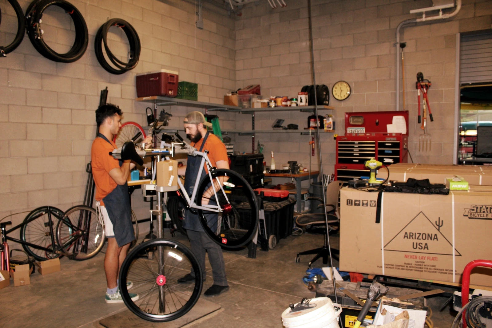 Two people lifting up a bike.