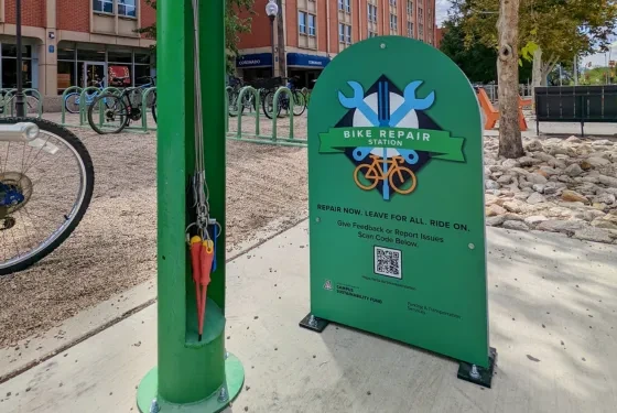 Tools for repairing a bike next to sign for a bike repair station.