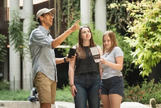 A group of people looking at brochure in a building, with one pointing.