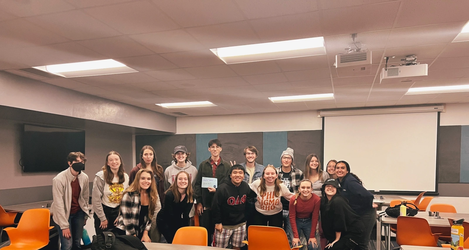 A group of students posing for a photo in a classroom. 
