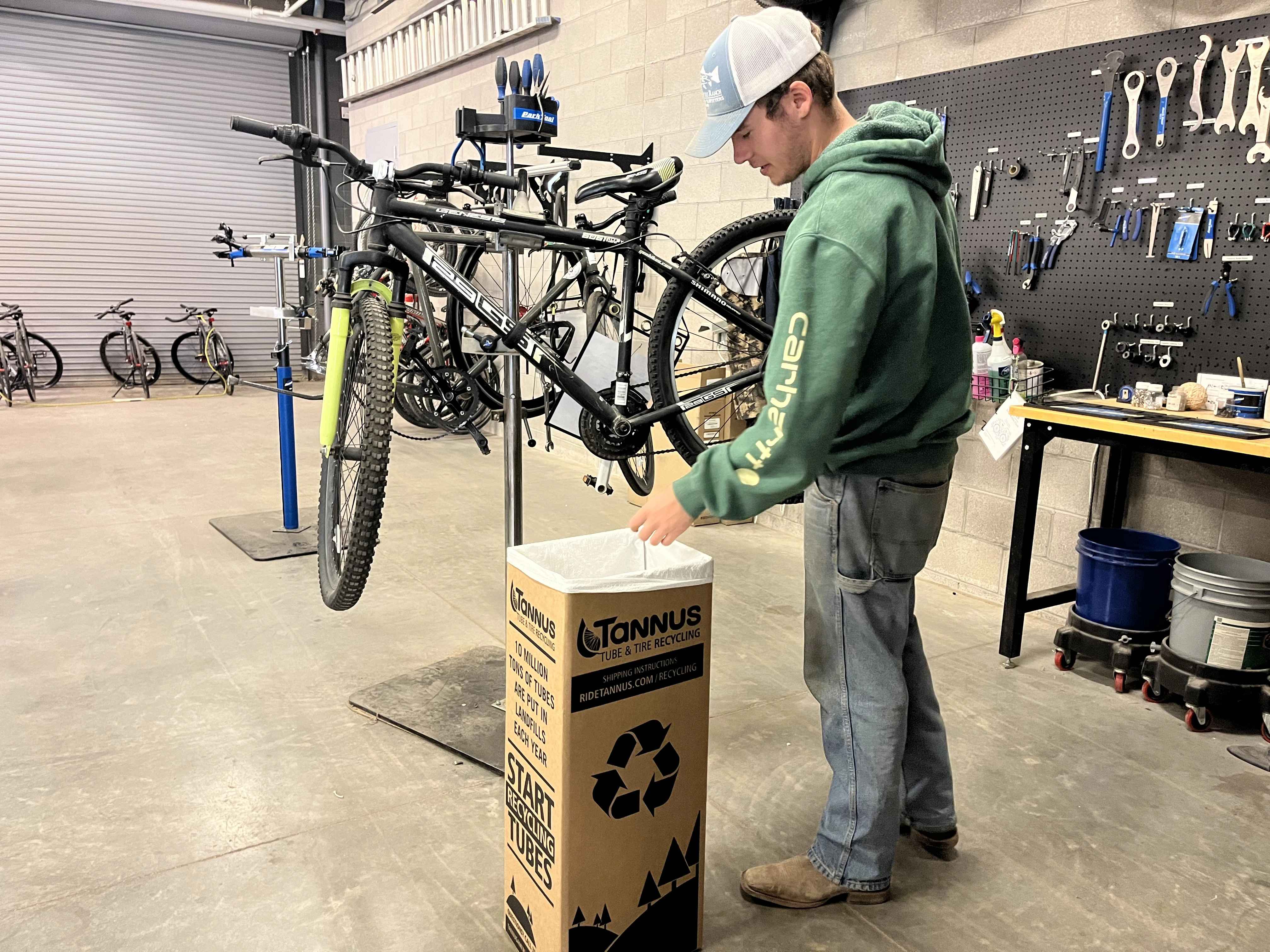 an employee uses a TerraCycle box for bike parts to be recycled as they fix a bike