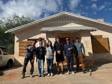 Team photo in front of one of the houses before it was renovated.