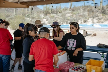 A group of students talking around a picnic table.