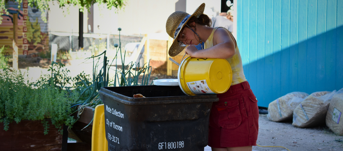 Student pouring compost from a yellow bucket.