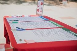 A red table with 3 big posters laying on top of it, side by side.