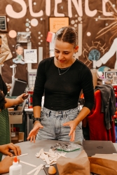 A person standing near a table talking.