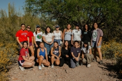 A group of people standing next to each other posing for a photo.