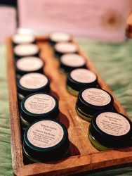 Multiple circular containers on a wooden holder. The containers have a Apapáchame Tierra desert medicine.