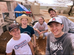 photo of five people smiling after digging the holes for trees to be planted