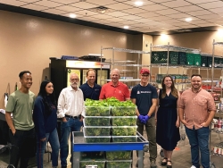 President Robbins with CSF and Biosphere 2 at Campus Pantry delivering lettuce