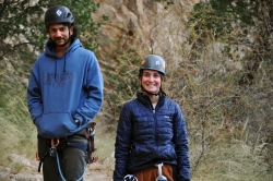 Two people smiling next to each other in a desert.