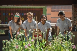 A group of four club members pose in front of their garden bed. 