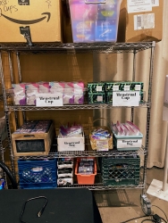 A storage rack that includes multiple bins of menstrual cups.