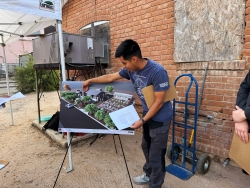 A person pointing at a photo diagram of two developed houses.