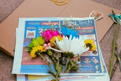 Various types of flowers laying on a newspaper that is on top of cardboard.