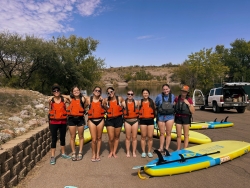 A group of people smiling for a photo wearing life vests.