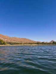 A large lake next to a mountain.