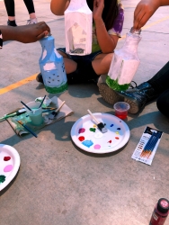 Students painting plastic bottles.