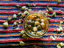 A bowl containing multiple flower buds with some buds surrounding the bowl on the outside.