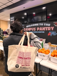 A person holding a reusable tote bag over their shoulder.